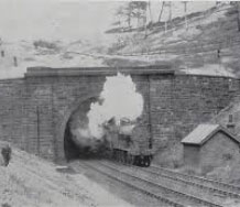 tunnel train tracks steam train grass black and white