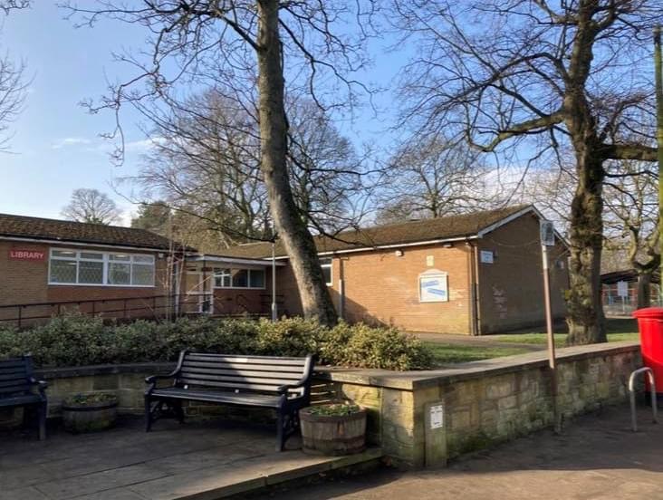 Photo of Gildersome Meeting hall, one storey building with parish notice board, bench red pillar post box bench